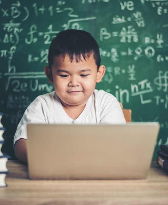 kid  use computer laptop  in the classroom.